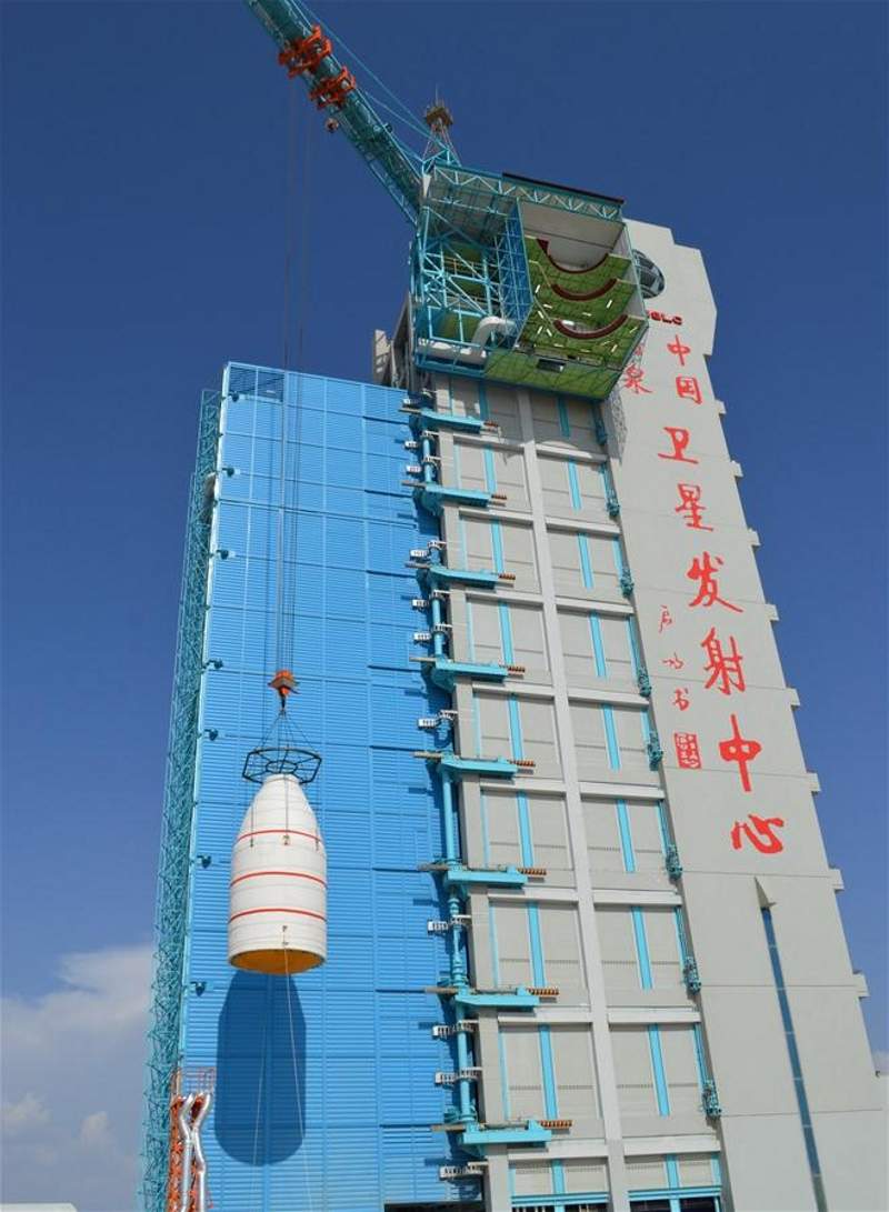 Micius satellite in its fairing being lifted for installation on the rocket. Credit: Xinhua.