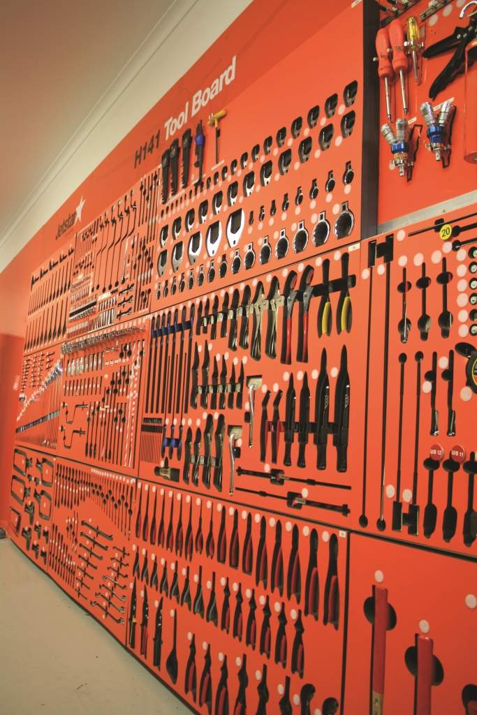 A red wall covered with tools